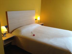 1 dormitorio con 1 cama blanca grande y mesita de noche en Apartament Can Callis en Castellón de Ampurias
