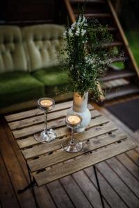 a table with two glasses and a vase with a plant at Namelis prie Magnolijos in Druskininkai