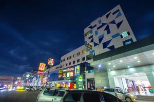 占碑市Wiltop Hotel Jambi的一条城市街道，建筑物前停着汽车