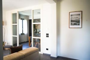 un salon avec un canapé et un miroir dans l'établissement Netik Apartment - Tuscany, à Cortone