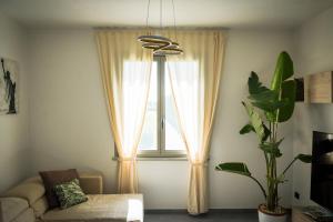 un salon avec un canapé et une fenêtre dans l'établissement Netik Apartment - Tuscany, à Cortone