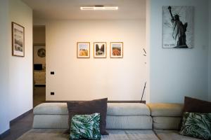 - un salon avec un canapé et des photos sur le mur dans l'établissement Netik Apartment - Tuscany, à Cortone 39 autres photos