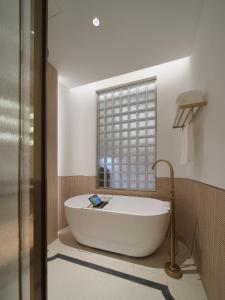 a bath tub in a bathroom with a window at The Stage Shanghai in Shanghai