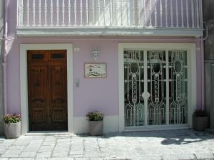 a pink building with two doors and two potted at A Casa di Teresa in Trecchina