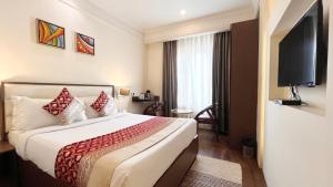 a hotel room with a bed and a flat screen tv at New Hotel Broadway in Varanasi +80 photos