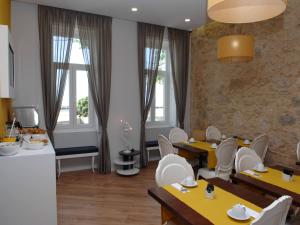 a restaurant with yellow tables and white chairs and windows at Marina Charming House in Figueira da Foz