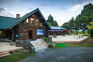 a log cabin with a deck and a patio at Reposer Hakuba in Hakuba