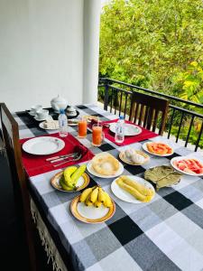 a table with plates of food on a checkered table cloth at Chamikara Homestay in Sigiriya