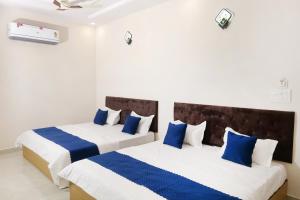 two beds in a room with blue and white at Hotel Sai Inn in Amritsar