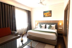 a hotel room with a bed and a couch at New Hotel Broadway in Varanasi