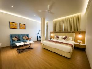 a hotel room with a large bed and a couch at New Hotel Broadway in Varanasi