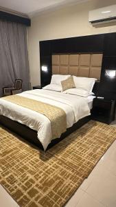 a bedroom with a large bed and a desk at منازل الحمراء السكنية للشقق المخدومة "إقتصادي" in Buraydah +77 photos