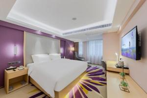 a bedroom with a large white bed and a flat screen tv at Lavande Hotel Shenzhen Bay Houhai Avenue in Shenzhen