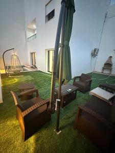 un patio avec des chaises et un parasol dans une pièce dans l'établissement Coquette villa, à Hammamet Sud