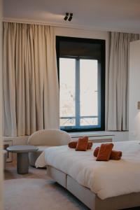 une chambre avec un lit et une grande fenêtre dans l'établissement Isidore, à Bruges
