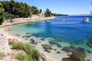 a beach with a group of people in the water at Apartments Miro with Sea view - near Beach in Sumartin