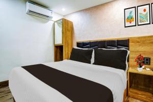 a bedroom with a black and white bed at Super Hotel O Santacruz Railway Junction Formerly Kharsubway in Mumbai
