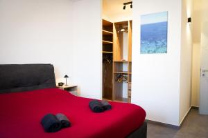- une chambre avec un lit rouge et des chaussures dans l'établissement Netik Apartment - Tuscany, à Cortone