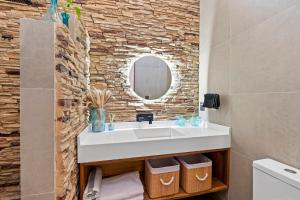 ChantepecにあるLa casita Blanca, it has everythingの洗面台と石の壁のあるバスルーム +19枚の写真