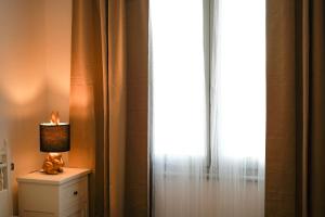 a lamp sitting on a dresser next to a window at Netik Apartment Cortona - Tuscan Vineyard escape in Cortona