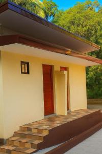 a small house with a red door and stairs at Bahay Domingo Guesthouse in Bagac