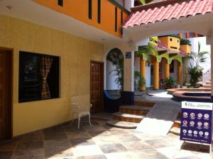a courtyard of a building with a table and chairs at El Tucan in Puerto Escondido