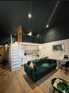 a living room with a green couch and a kitchen at Piotrkowska 37 -MINI LOFT- Green Leaf in Łódź