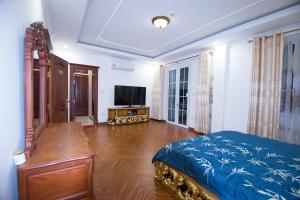 a bedroom with a bed and a television in it at Lưu trú Vạn Lợi in Ho Chi Minh City