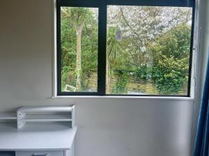 een raam in een kamer met een wit bureau ervoor bij Ke's home in Wellington