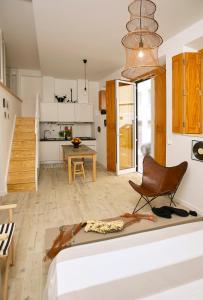 a room with a bed and a chair and a kitchen at Casa da Irene in Nazaré