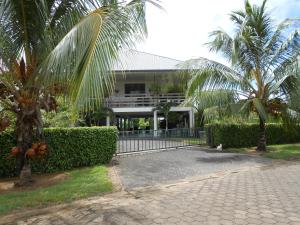 ein Gebäude mit Palmen vor einer Einfahrt in der Unterkunft Palm Village 134 in Paramaribo