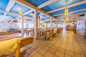 a restaurant with wooden ceilings and tables and chairs at Karczma Kubalonka in Istebna