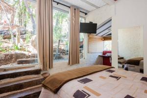 a bedroom with a bed and a large window at Pousada Santa Vila in Serra do Cipo