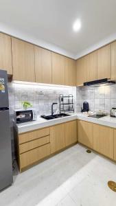 a large kitchen with wooden cabinets and a sink at The Golden Town CNX private house in Chiang Mai