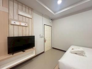 a white room with a television and a bed at Sunrise House at Lanta in Ban Nong Chaeng