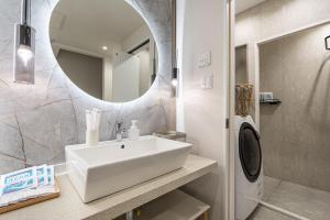 ein Badezimmer mit einem weißen Waschbecken und einem Spiegel in der Unterkunft STAY ARI Higashishinjuku in Tokio + 14 Fotos