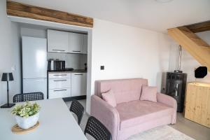 a living room with a pink chair and a table at Hill Stars House in Straža