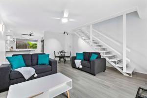 un soggiorno con 2 divani e una scala di Coast Apartments 2 Bedroom Getaway a Torquay