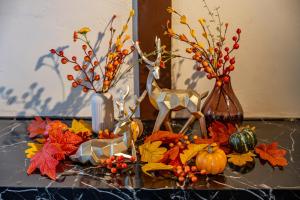 a table topped with autumn leaves and vases with pumpkins at Lax奈良 奈良観光に便利な和モダン古民家 最大12名 グループや家族旅行に最適 in Nara