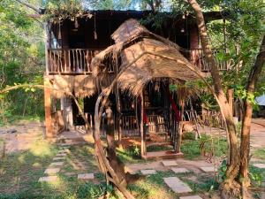 an old house with a palm tree in front of it at Sigiri Tree Cabana in Sigiriya