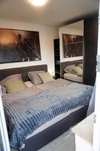 a bedroom with a large bed and two paintings on the wall at M House Do City Privatzimmer mit Balkon & Self Check-in in Dortmund