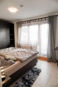 a bedroom with a bed and a large window at M House Do City Privatzimmer mit Balkon & Self Check-in in Dortmund