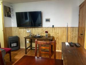 un salon avec une table et une télévision sur un mur dans l'établissement Condominio Matta Torre 1, à Temuco 5 autres photos