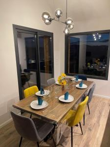 Puy-SanièresにあるSpacious house with stunning views Puy-Sanièresの黄色の椅子とダイニングルームのテーブルとダイニングルームのテーブル