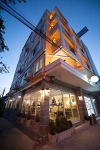 um edifício com muitas janelas numa rua em Hoppers Place Donmuang Hostel em Banguecoque