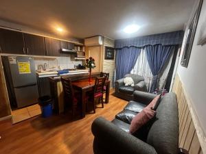 une cuisine et un salon avec un canapé et une table dans l'établissement Condominio Matta Torre 1, à Temuco