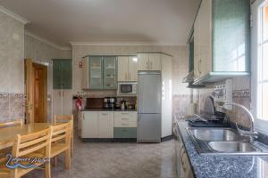 a kitchen with a refrigerator and a table in it at Duas Aguas Arribes in Bemposta