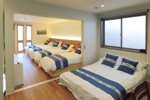 a row of four beds in a room at 森の晴 in Osaka