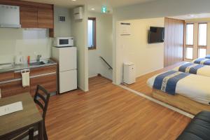 a hotel room with two beds and a kitchen at 森の晴 in Osaka