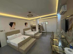 a living room with two beds and a television at Golden Bliss hotel in San Josef